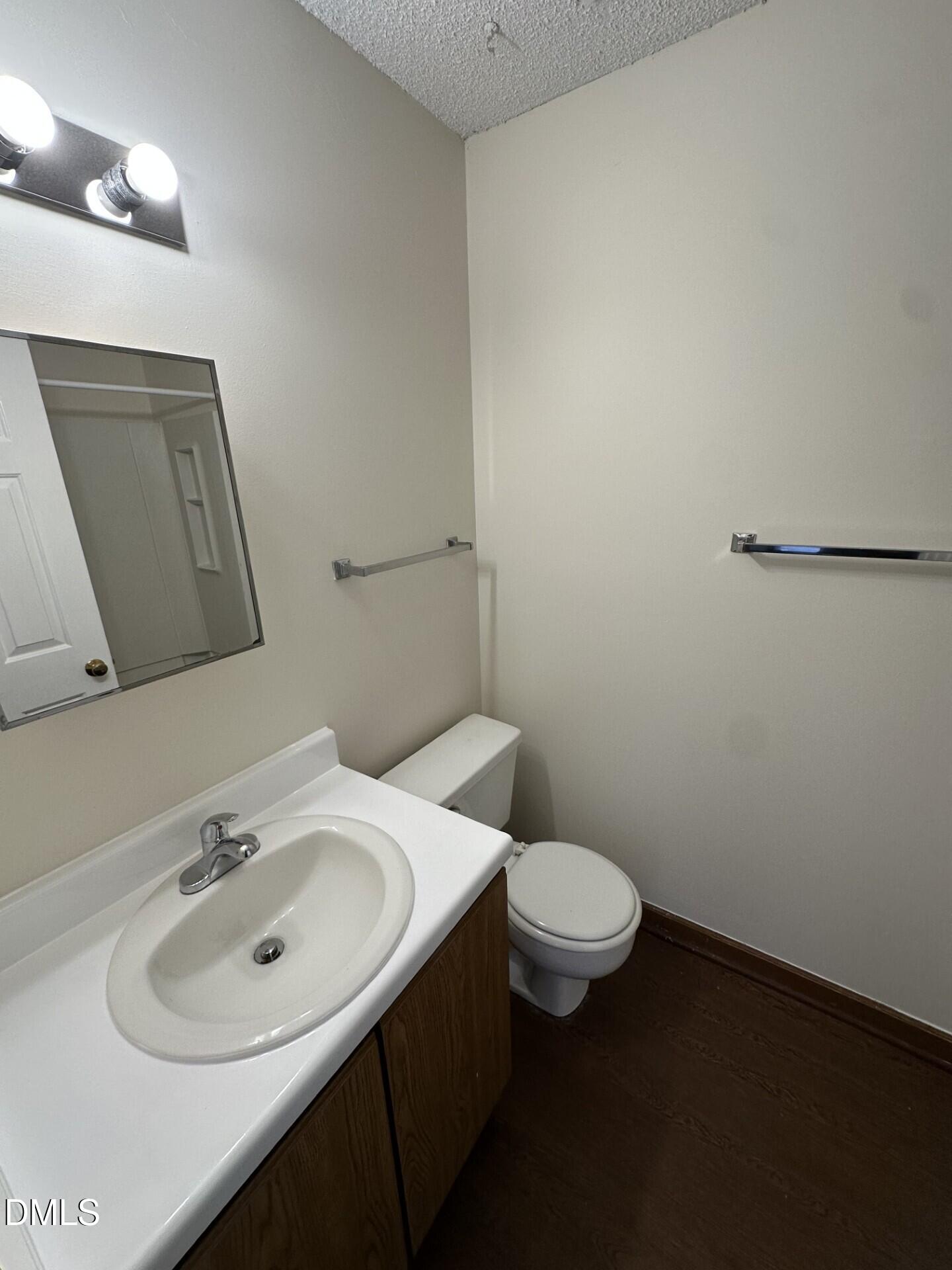 3530 Ivy Commons Drive, Unit 201 Raleigh, NC 27606 - Photo 5 of 6 a bathroom with a sink a toilet and mirror