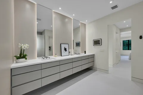 a bathroom with a double vanity sink mirror and bathtub