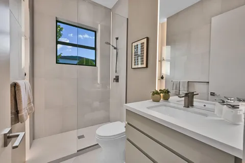 a bathroom with a sink a toilet and shower