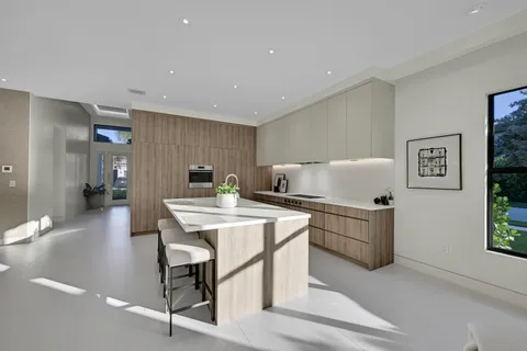 a kitchen with kitchen island a stove a table and chairs in it