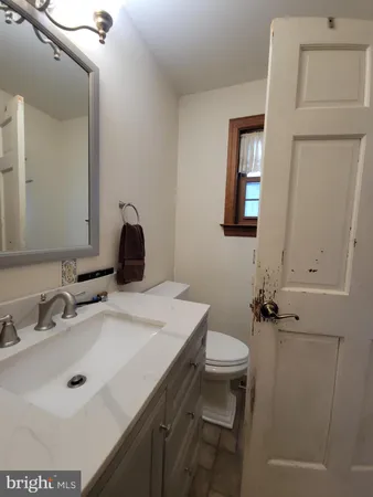 a bathroom with a sink toilet and mirror