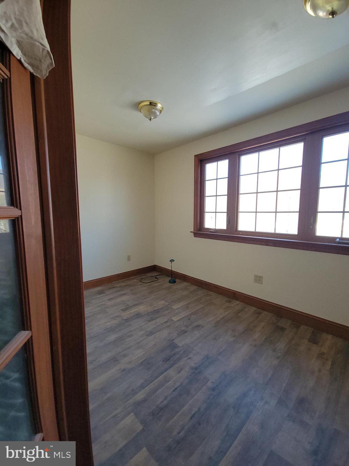 565 Main Street Lykens, PA 17048 - Photo 22 of 29 an empty room with wooden floor and windows