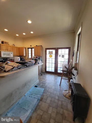 a view of a kitchen with kitchen island granite countertop lots of counter top space a sink and appliances