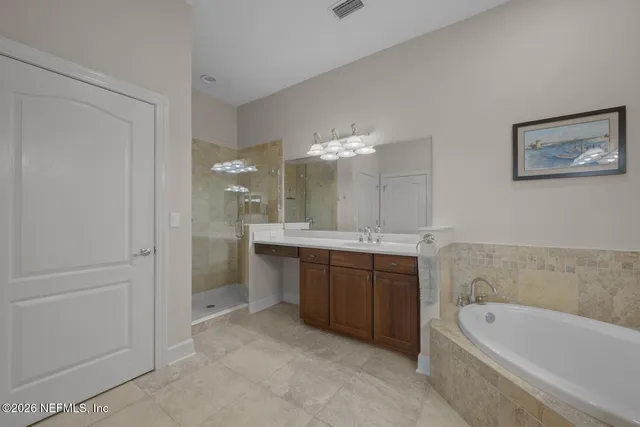 a bathroom with a tub a sink and mirror
