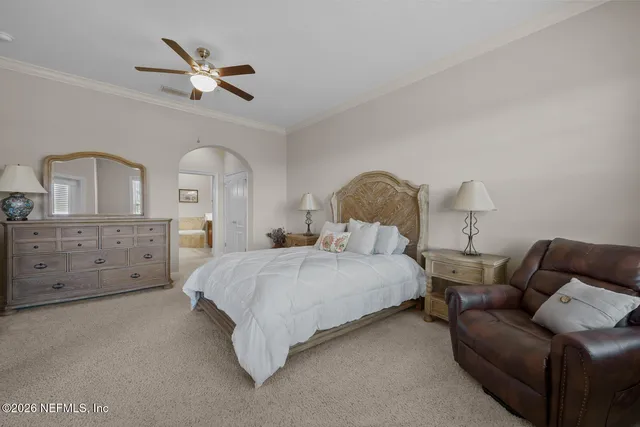 a spacious bedroom with a bed a couch and dresser