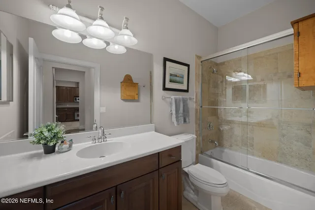 a bathroom with a sink a toilet and a large mirror