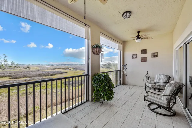 a view of a terrace with furniture and a floor to ceiling window