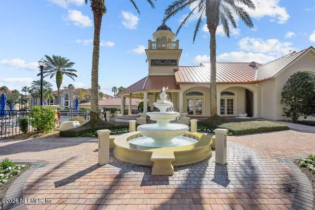 a view of a patio with couches table and chairs under an umbrella