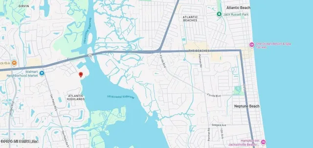 an aerial view of ocean and residential houses with outdoor space