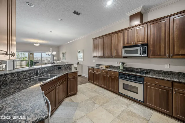 a kitchen with stainless steel appliances granite countertop a stove top oven a sink and dishwasher