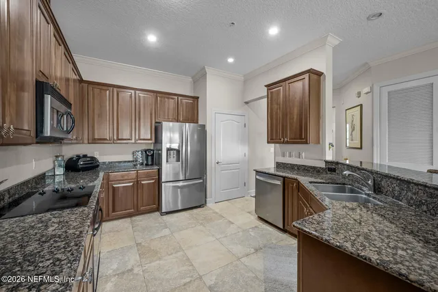 a kitchen with refrigerator stove microwave and sink