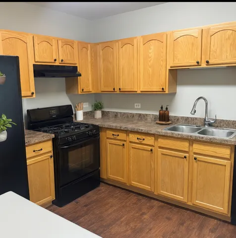 a kitchen with granite countertop a sink cabinets and stainless steel appliances