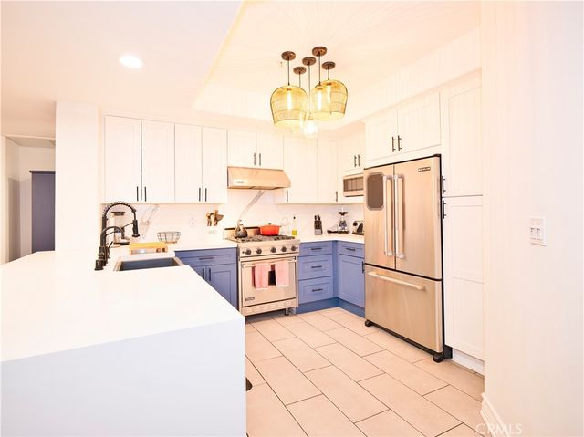a kitchen with stainless steel appliances a refrigerator sink and cabinets
