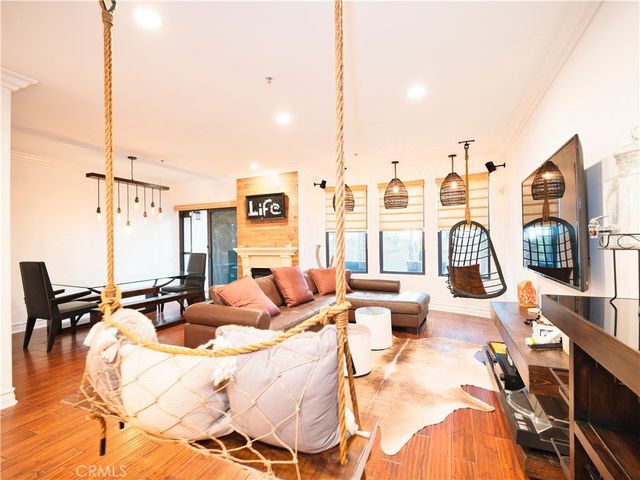 a living room with furniture large window and wooden floor