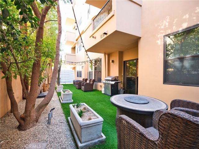 a view of a patio with couches table and chairs with plants and garden
