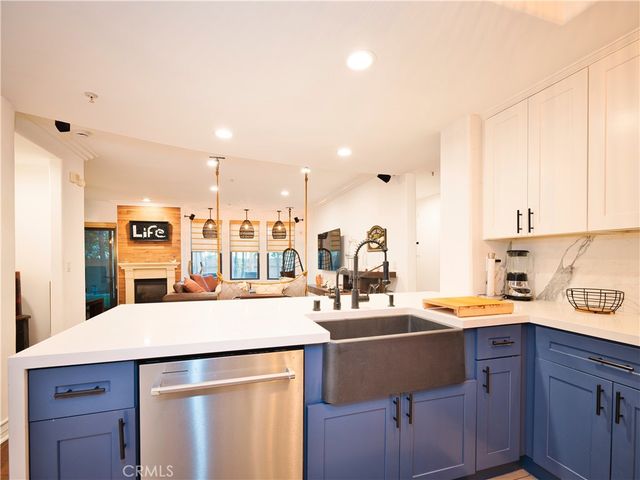 a kitchen with a sink a stove cabinets and wooden floor