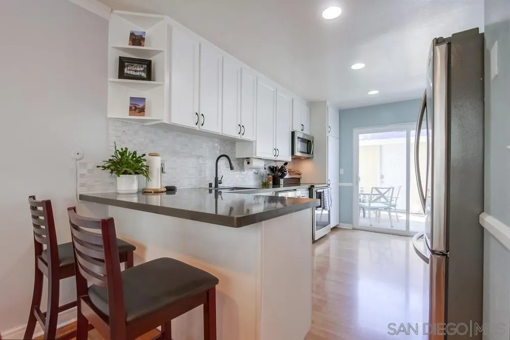 284 Gardendale Road Encinitas, CA 92024 - Photo 24 of 59 a kitchen with stainless steel appliances granite countertop a refrigerator a sink a stove and white cabinets with wooden floor