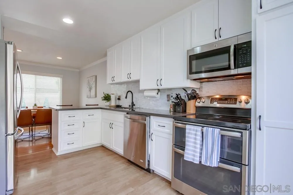 284 Gardendale Road Encinitas, CA 92024 - Photo 27 of 59 a kitchen with granite countertop white cabinets and stainless steel appliances