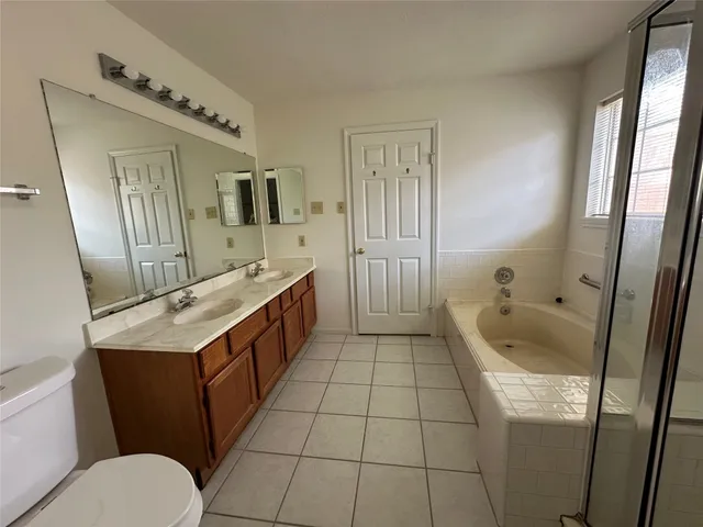 a bathroom with a granite countertop sink mirror vanity and toilet