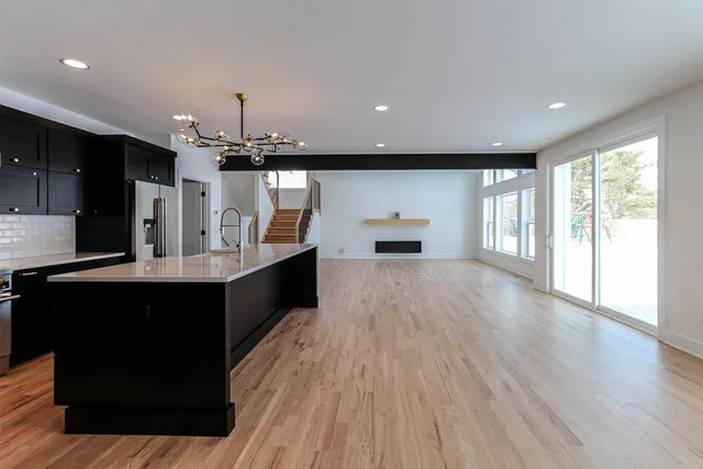 a large kitchen with stainless steel appliances a large counter top a refrigerator and a sink