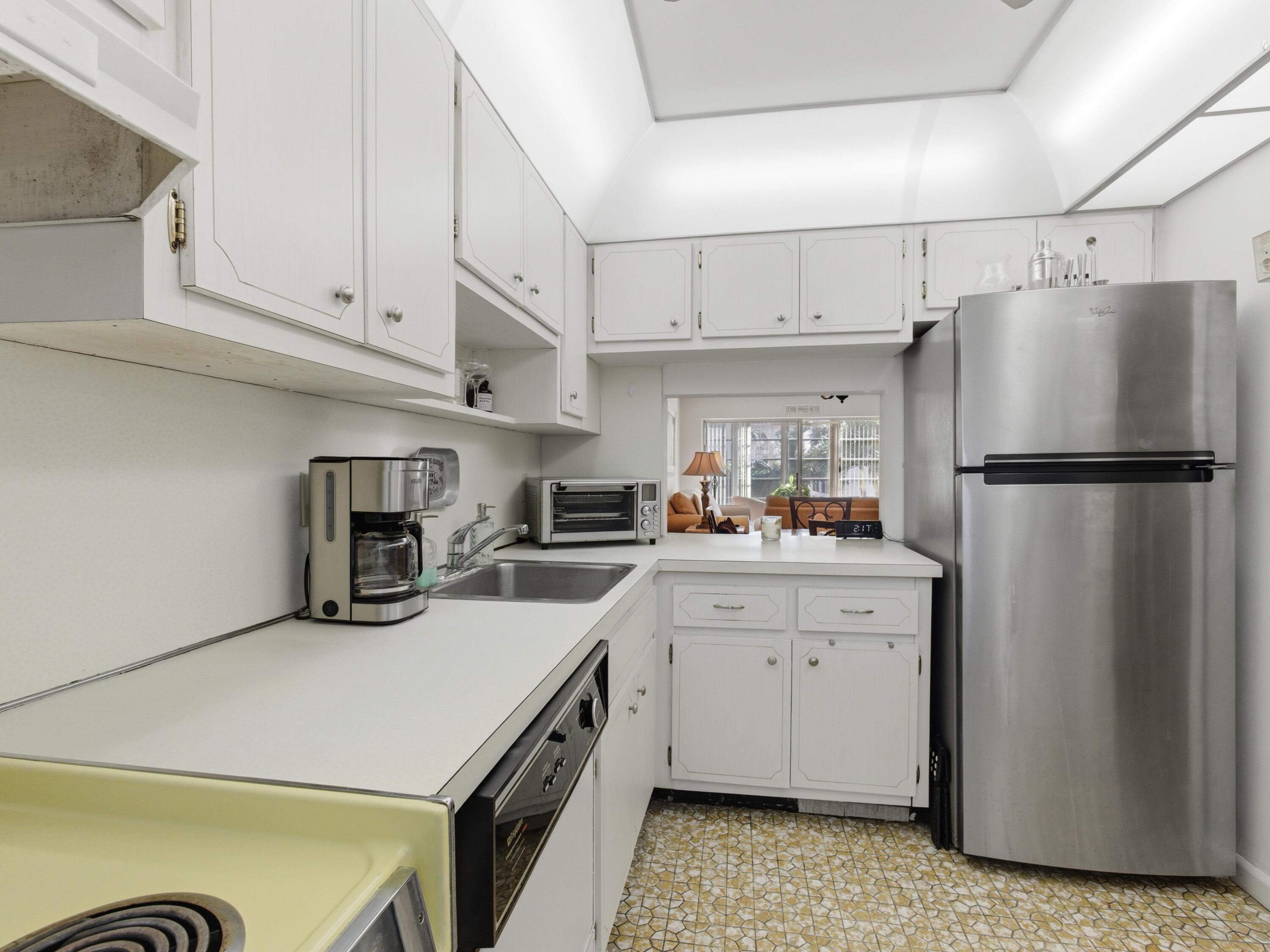 400 Northeast 20th Street, Unit A216 Boca Raton, FL 33431 - Photo 15 of 32 a kitchen with refrigerator and cabinets