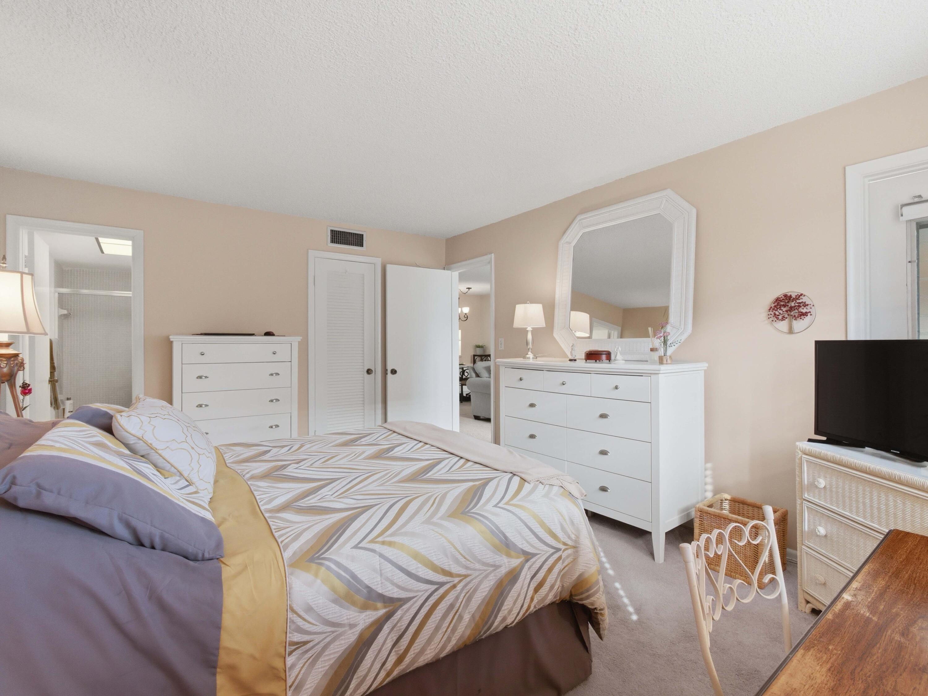 400 Northeast 20th Street, Unit A216 Boca Raton, FL 33431 - Photo 23 of 32 a bedroom with a bed and a flat screen tv