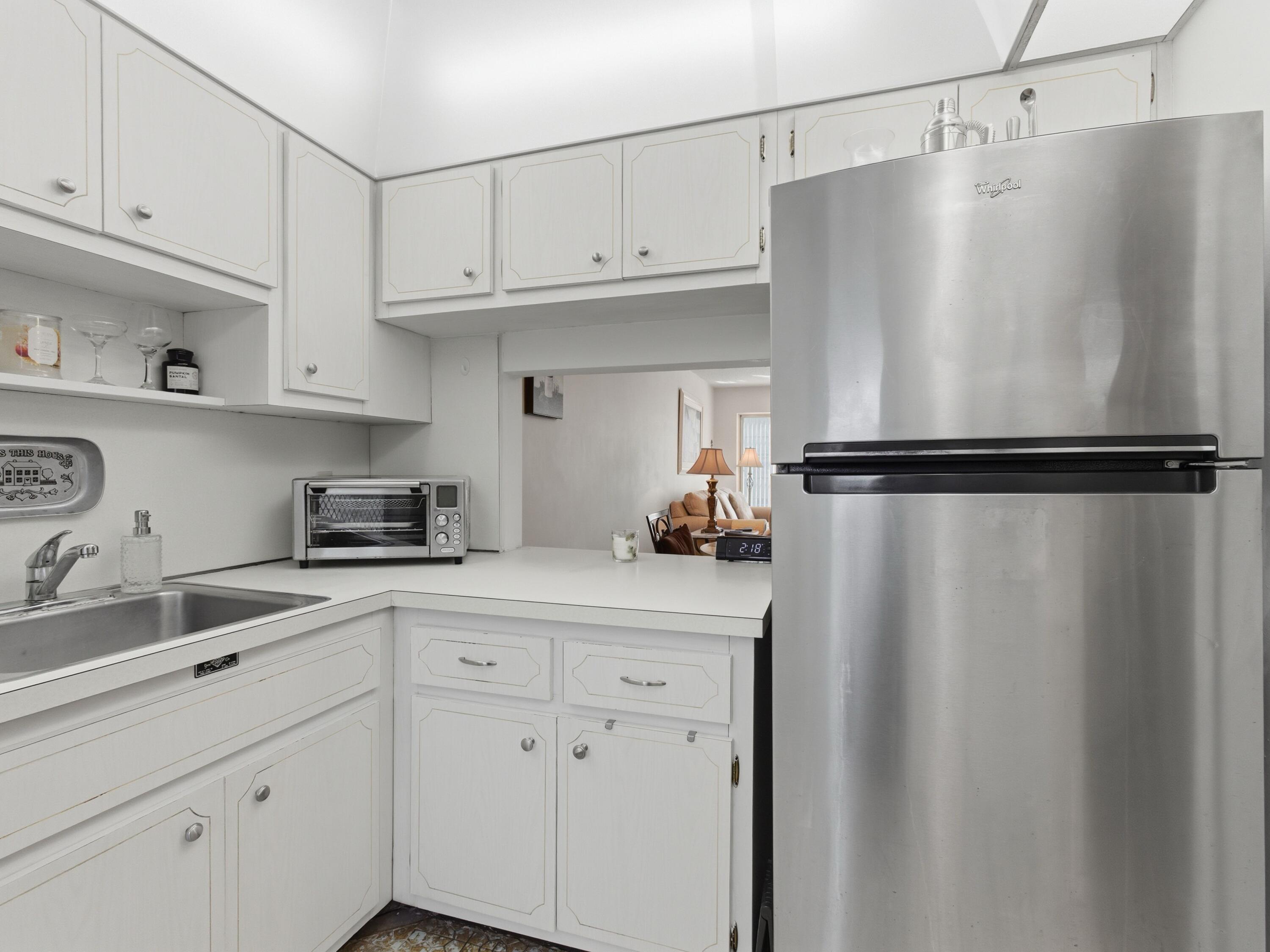 400 Northeast 20th Street, Unit A216 Boca Raton, FL 33431 - Photo 4 of 32 a kitchen with cabinets and a refrigerator