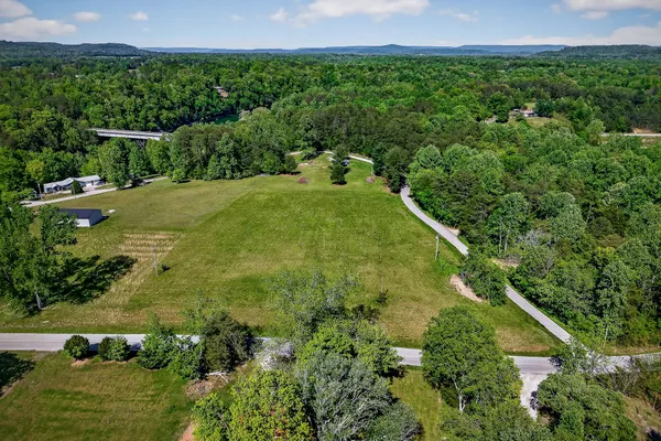 an aerial view of residential houses with outdoor space and trees