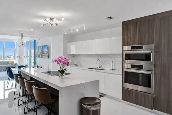 a kitchen with granite countertop a sink cabinets and stainless steel appliances