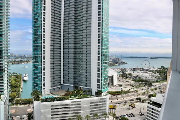 a bedroom with a bed a flat screen tv and a large window