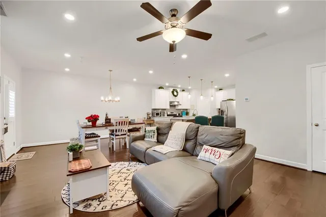 a living room with furniture kitchen view and a chandelier