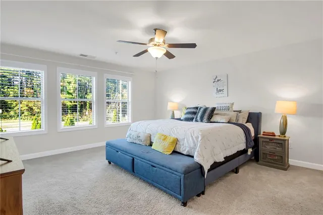 a spacious bedroom with a bed and a chandelier