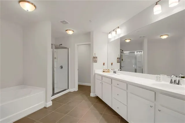 a bathroom with a double vanity sink a toilet and shower