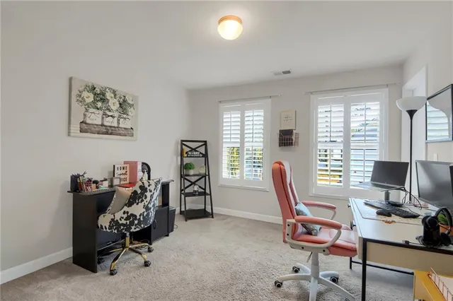 a view of a workspace with furniture and a window