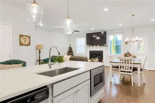 a kitchen with a sink a stove and kitchen island with wooden floor