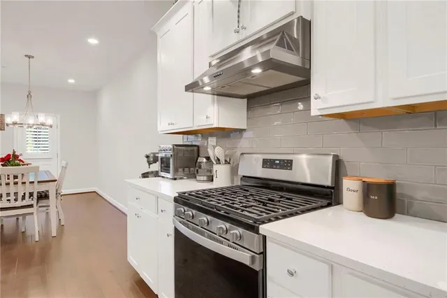 a kitchen with a stove and a wooden floor
