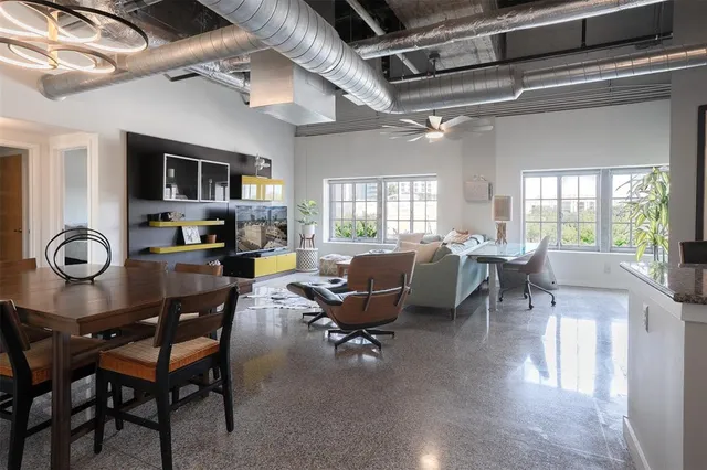 a living room with furniture a dining table and a floor to ceiling window