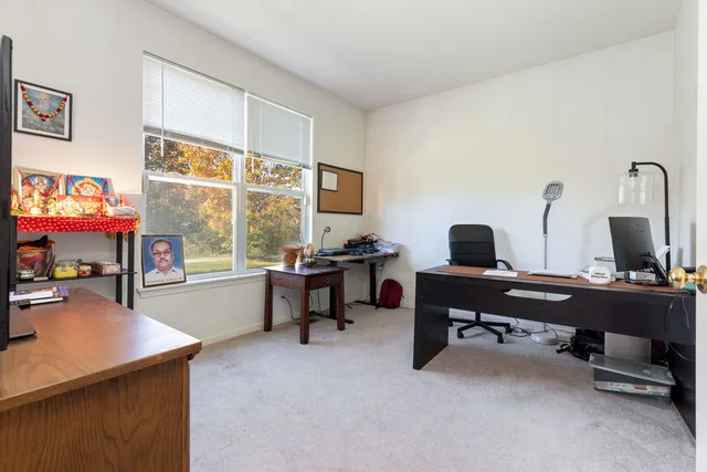 a view of a workspace with furniture and a window