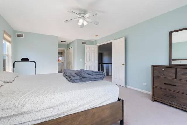 a spacious bedroom with a bed and a large window