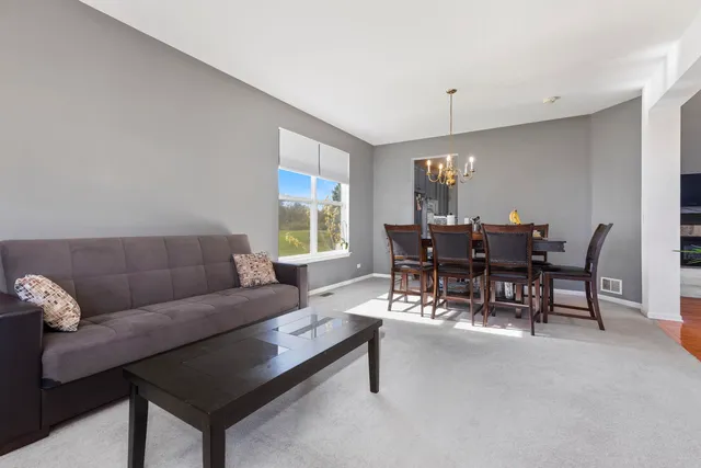 a living room with furniture and a dining table