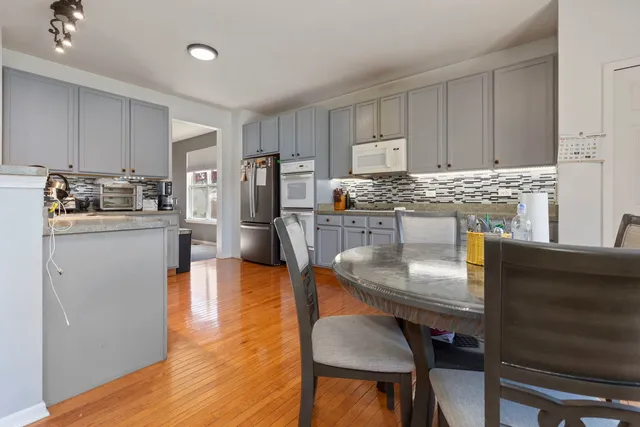 a kitchen with kitchen island a stove a table and chairs in it