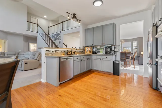 a kitchen with stainless steel appliances granite countertop a sink counter space and wooden floor