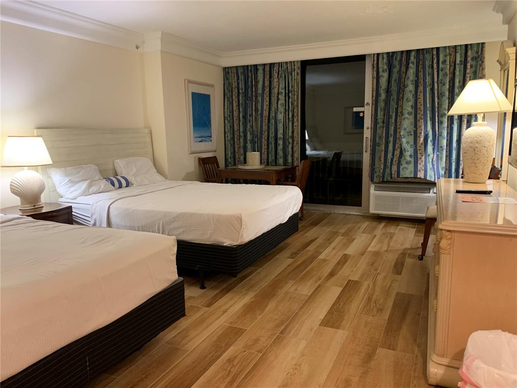 2700 North Atlantic Avenue, Unit 548 Daytona Beach, FL 32118 - Photo 6 of 6 a bedroom with two beds and a flat tv screen on dresser