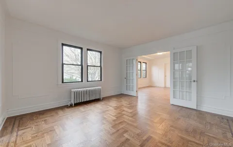 an empty room with windows and ceiling fan