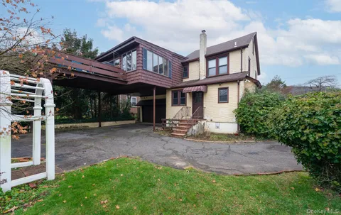 a view of a house with a yard and sitting area