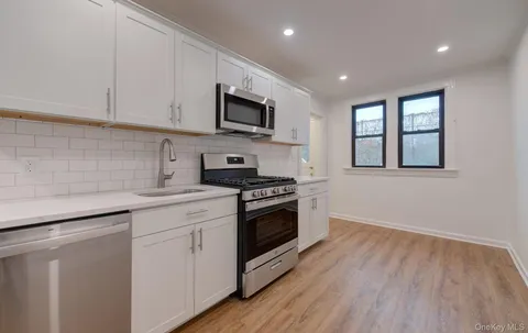 a kitchen with stainless steel appliances granite countertop a sink a stove a microwave and cabinets