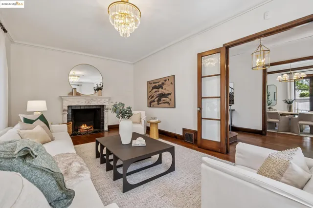 a living room with furniture a chandelier and a fireplace