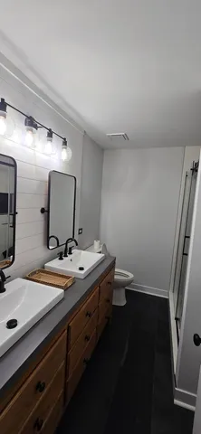 a bathroom with a sink a toilet and mirror