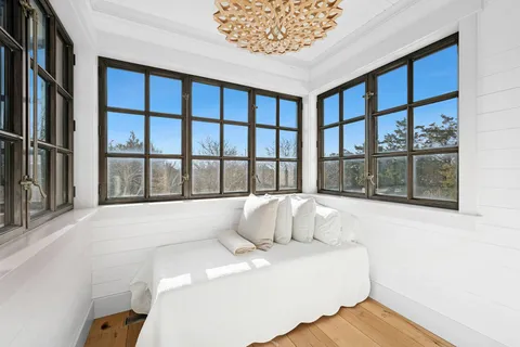 a large white bed sitting in a room next to a window