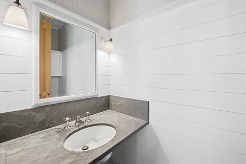 a bathroom with a granite countertop sink and a mirror